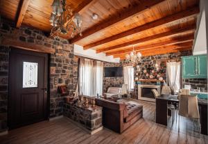 uma sala de estar com tectos de madeira e uma parede de pedra em Villa Avia em Milatos