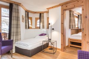 a bedroom with a bed and a table in a room at Hotel Bella Vista Zermatt in Zermatt