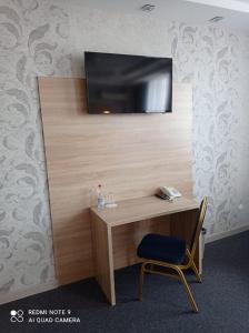 KachkanarにあるHotel Pyaterochka Luxのデスク(テレビ付)、壁掛けテレビ(椅子付)