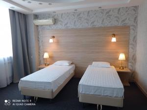 KachkanarにあるHotel Pyaterochka Luxのベッド2台 ホテルルーム ランプ2つ付