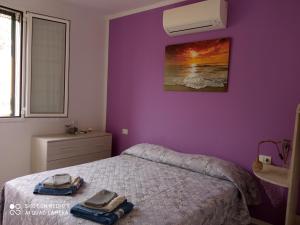 a bedroom with a bed with a purple wall at Verde Mare in Alassio