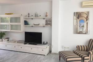 - un salon avec une télévision et deux chaises dans l'établissement Eclipse de mar: Cozy Beach Home, Costa de la Luz, à Cadix
