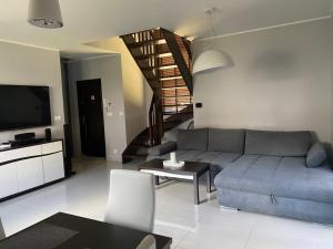 salon z kanapą i stołem w obiekcie Hire House w Pobierowie