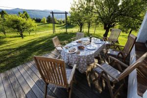 a wooden deck with a table and chairs on it at Unique Cottage House With Panoramic View On Ravnik in Hotedršica