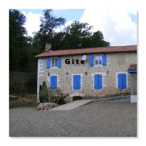 un edificio de piedra con puertas y ventanas azules en Gîte du Moulin en Gamarde-les-Bains
