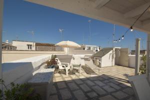 a patio with a table and an umbrella and chairs at Casa RoSiLù in Monopoli