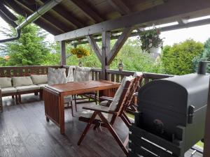 a patio with a wooden table and a grill at Chalupa Šiška in Záhoří