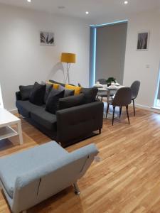 a living room with a black couch and a table at Gillingham One in Gillingham