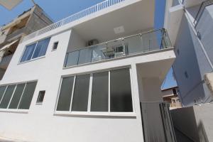 a house with large windows and a balcony at Deda Apartments in Sarandë