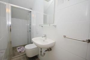 a bathroom with a sink and a toilet and a shower at Apartmani Batinović - Baška Voda in Baška Voda