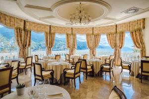 a dining room with tables and chairs and a chandelier at Excelsior Palace Portofino Coast in Rapallo