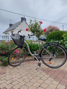 un vélo avec panier est garé sur un trottoir dans l'établissement TY ANN maison avec jardin clos de mur, à proximité des commerces et à 3km des plages, à Penvénan