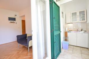 a living room with a green door and a chair at Marios in Brela +35 photos