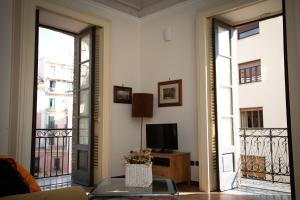 een woonkamer met een bank en een tv op een balkon bij Flavio Gioia Suite Salerno in Salerno