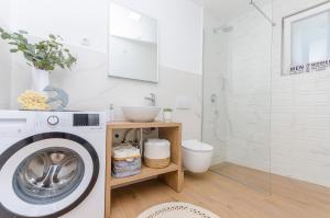 a bathroom with a washing machine and a shower at Sunset horizon in Krapanj