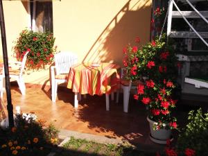 einen Tisch und Stühle auf einer Terrasse mit Blumen in der Unterkunft Matild Apartmanház in Siófok