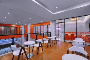 a restaurant with white tables and white chairs at Starlet Hotel BSD City in Tangerang