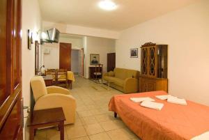 a bedroom with a bed and a living room at Sunset Hotel Parga in Parga
