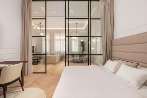 a bedroom with a white bed and a dining room at Plaza Apartments in Opatija