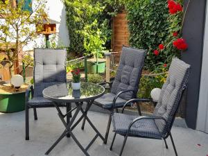 three chairs and a table on a patio at Haus Monika in Zeltingen-Rachtig