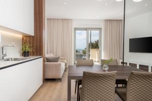 a kitchen and a dining room with a table and chairs at Plaza Apartments in Opatija