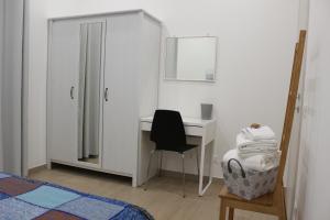 um quarto com uma secretária, uma cama e uma cadeira em L'Angoletto#2 em Ciampino