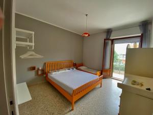 ein Schlafzimmer mit einem Bett und einem großen Fenster in der Unterkunft La Marinella in Massignano