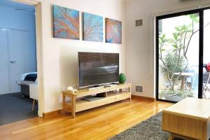 een woonkamer met een flatscreen-tv op een tafel bij Underwater Oasis Freo - 2BRM with Courtyard & 1 Car Bay in Fremantle