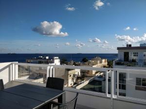 uma varanda com uma mesa e vista para o oceano em Sea View Penthouse with large terrace IROM1-1 em Marsaskala