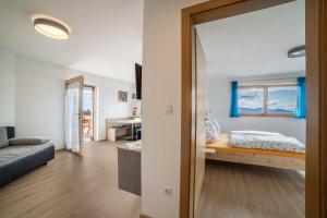 a living room with a bed and a mirror at Ferienwohnung Oberhochmuthof in Tirolo