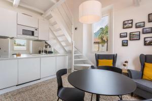 a kitchen and a living room with a table and chairs at Varenna amorevole dimora in Lecco in Lecco