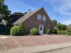 a brick house with a basketball court in the driveway at Grodenblick in Hooksiel