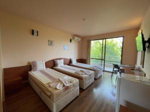 a living room with two beds and a couch at Hotel Vega in Kranevo
