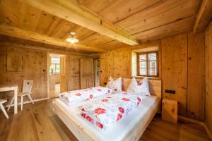 a bedroom with a bed in a log cabin at Schnitzers Ferienheisl in San Leonardo in Passiria