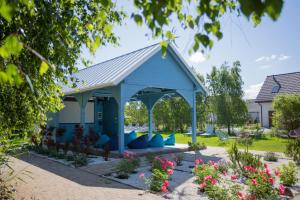 a blue pavilion with blue pillows in a garden at Apartamenty Łeba - Polanki23 - basen, sauna, kino in Łeba