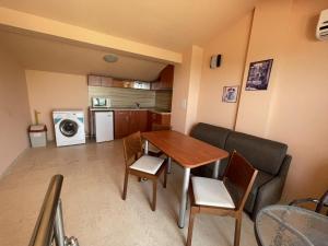 a kitchen and living room with a table and chairs at Hotel Vega in Kranevo