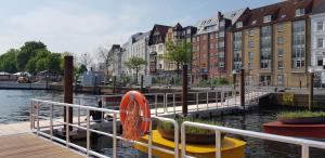 un bateau amarré à côté d'une rivière avec des bâtiments dans l'établissement Hansekoje direkt an der Hafenspitze, à Flensbourg