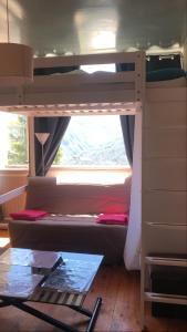 ein Schlafzimmer mit einem Etagenbett und einem Fenster in der Unterkunft Chez So Orcieres in Orcières