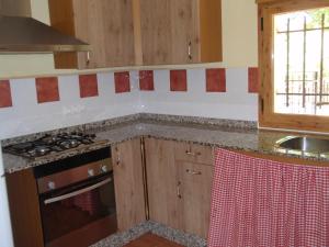 Una cocina con gabinetes de madera y un horno de estufa. en El Molino de Iramala, en Reolid 27 fotos más