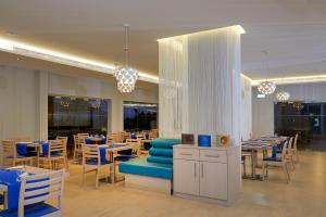 a restaurant with blue tables and chairs and tables and chairs at Melia Dunas Beach Resort & Spa in Santa Maria