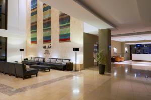 a lobby of a hotel with couches and a sign on the wall at Melia Dunas Beach Resort & Spa - All Inclusive in Santa Maria