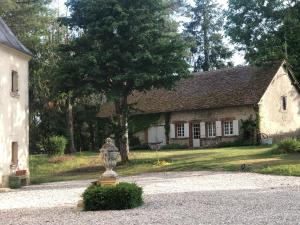 a stone house with a statue in front of it at The cosy retreat in Mornay-sur-Allier