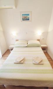 a bedroom with two beds with towels on them at Apartments Vjeko in Split