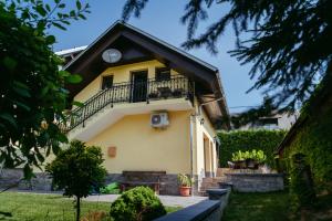 Cette maison jaune dispose d'un balcon et d'un escalier. dans l'établissement Apartment Oddih with terrace and private SAUNA, à Bled