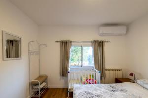 1 dormitorio con cuna y ventana en אירוח הר אודם, en Odem