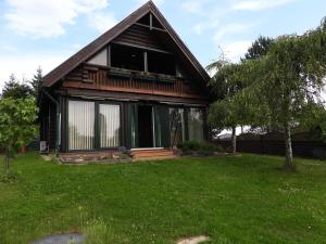 a house with a large window on a green yard at Meseház Apartman in Zalalövő