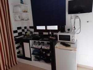 eine Küche mit einer Theke und einem TV darüber in der Unterkunft Apartamento tranquilo in Playa Blanca