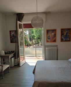 - une chambre avec un lit et une porte coulissante en verre dans l'établissement Rossetto e cocciolato - Stanza indipendente con bagno privato a Pesaro, à Pesaro