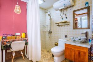 een badkamer met een toilet, een wastafel en een spiegel bij Hangzhou Citynest Music B&B in Hangzhou