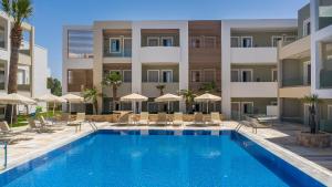 a swimming pool with a blue chair and a blue umbrella at Mythos Hotel Apartments in Tigaki